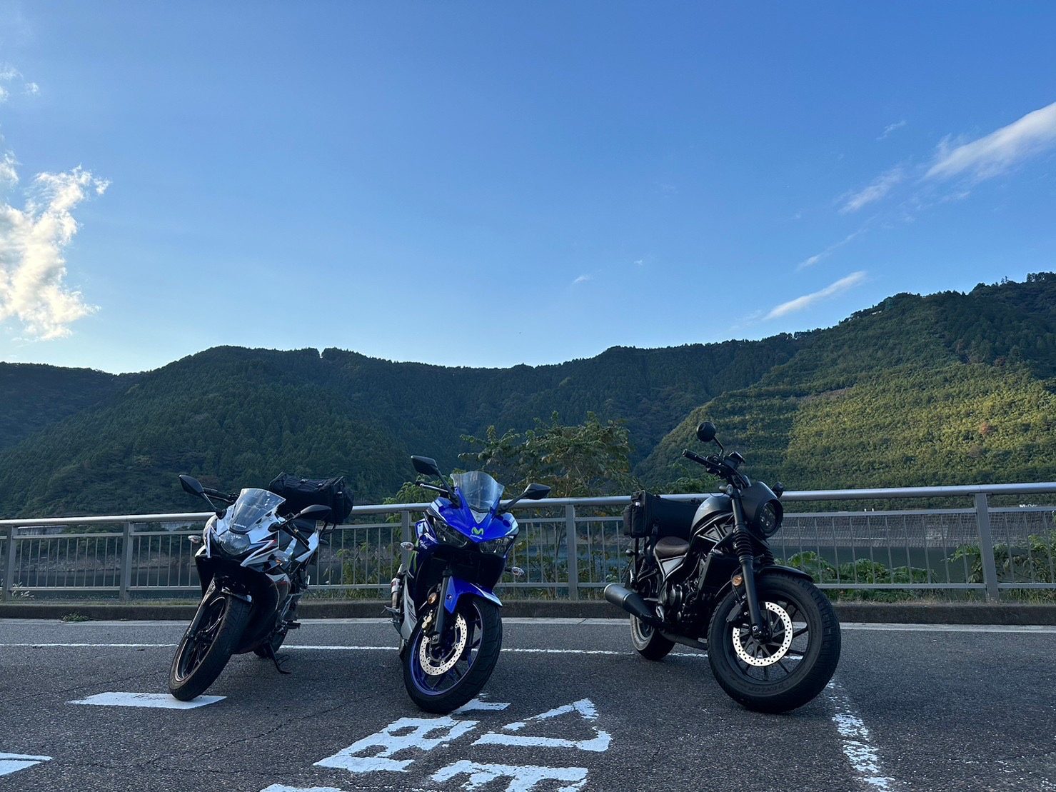 3台を後方から。この時間帯は雲ひとつない青空で、送電線の鉄塔が立つ稜線まで見通せた