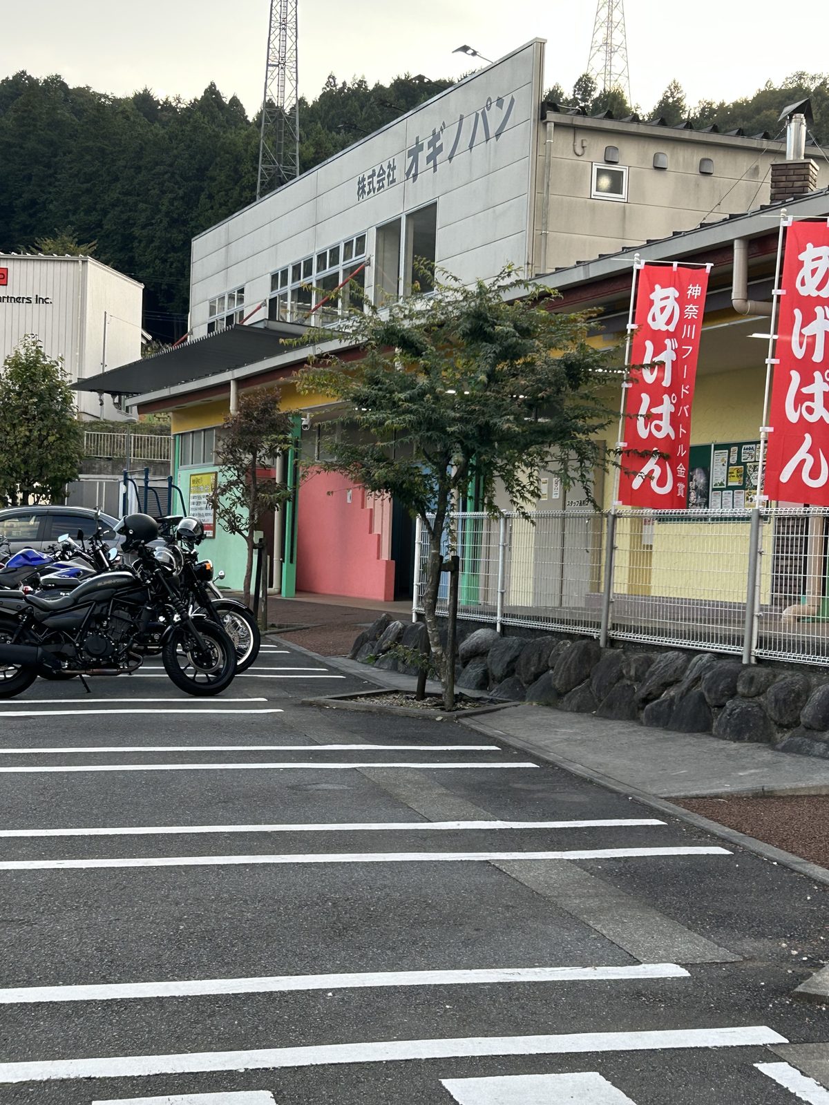 帰路に立ち寄ったオギノパンの店舗前。「あげぱん」ののぼりが並び、駐輪スペースに3台を停めた。16時23分